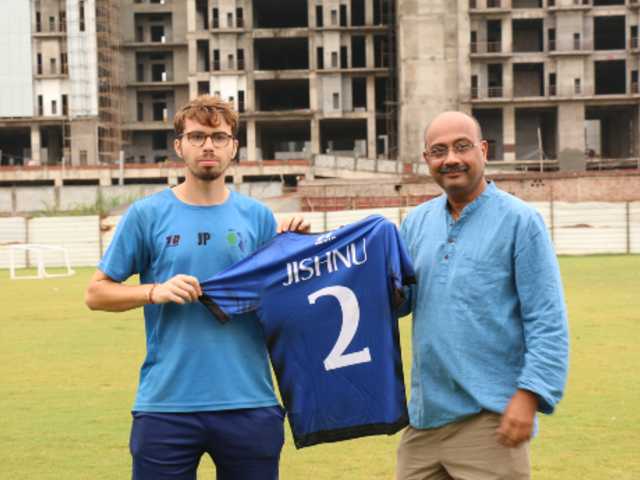 head coach jack pottinger and jmf founder jagdish mitra holding jmf jersey